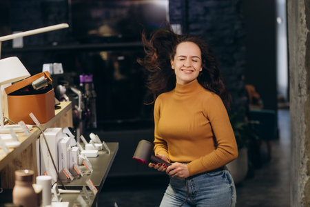 A buy womans a hair dryer in an electronics store.の写真素材