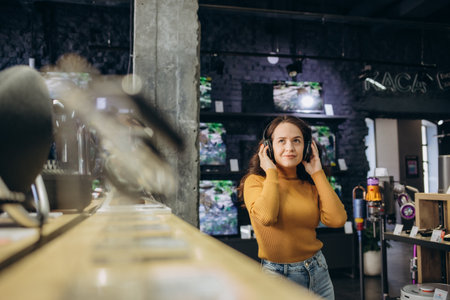 Happy customer choosing headphones in audio store.の写真素材