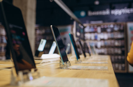 Showcase with smartphones in the modern electronics store. Buy a mobile phone. Many smartphones on the shelf of the technology storeの写真素材