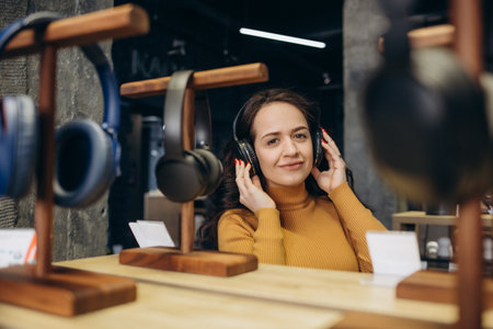 Woman trying on headphones in acoustics store.の写真素材
