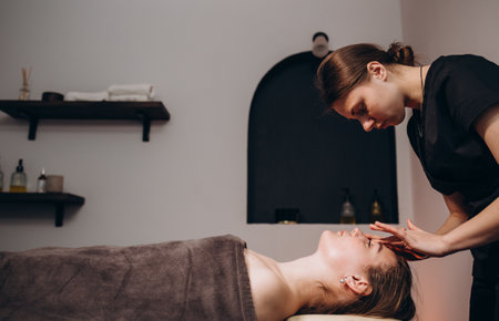 Beautiful girl has a facial massage in a beauty clinic.の写真素材
