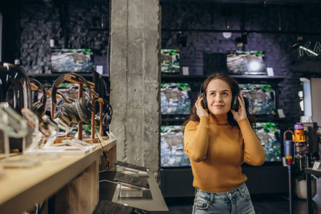Woman trying on headphones in acoustics store