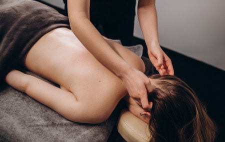 Young woman having facial massage in beauty salon.の写真素材