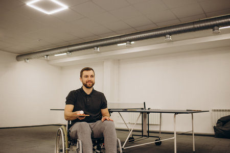 A boy in a wheelchair plays table tennis.の写真素材
