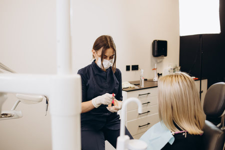 Over the shoulder view of a dentist examining a patient teeth in dental clinic. Female having her teeth examined by a dentist.の写真素材