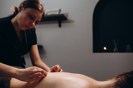 Spa woman. Female enjoying relaxing back massage in cosmetology spa centre. Body care, skin care, wellness, wellbeing, beauty treatment concept.の写真素材