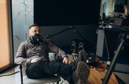 Portrait of smiling hispanic male radio presenter with clipboard hosting a show at radio stationの写真素材