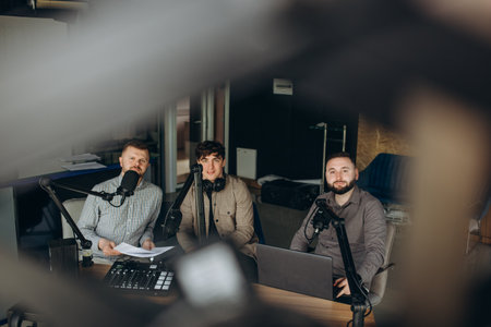 Fine presenters of different nationalities in sound broadcasting station hosting live radio showの写真素材