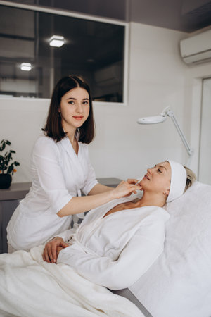 The doctor cosmetologist makes Lip augmentation procedure of a beautiful woman in a beauty salon. Prp therapy, anti wrinkle and aging skin. Cosmetology skincare.の写真素材