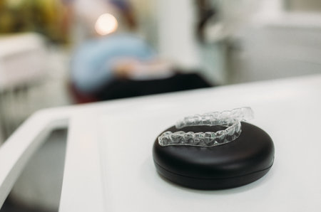 Invisible orthodontics cosmetic brackets on gradient background, tooth aligners, plastic braces. Modern teeth retainers created on a 3d printer. A way to have a beautiful smile and white teeth.の写真素材
