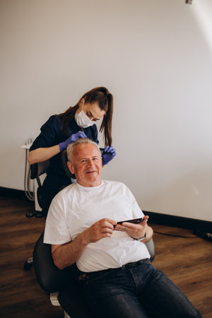 an old man is being examined by a trichologist.の写真素材