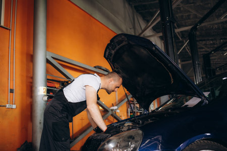 Portrait of mechanic checking parts of automobile.の写真素材