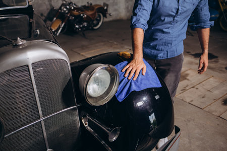 a man wipes a retro car close-up.の写真素材