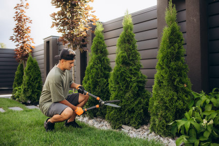 Professional Gardener at Work. Gardener Trimming Garden Plants. Topiary Art