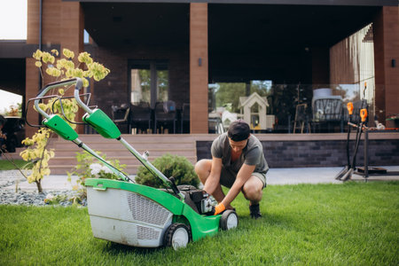 Man portrait moving the lawn with lawnmower having problem.