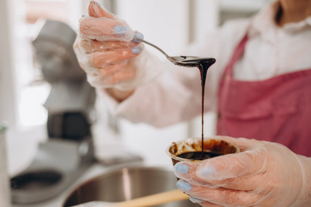 culinary, baking and cooking food concept - happy smiling young woman making layer cake on kitchen at homeの写真素材