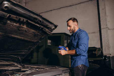 a man repairs a retro car in a garage.の写真素材