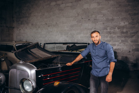 a man repairs a retro car in a garage.