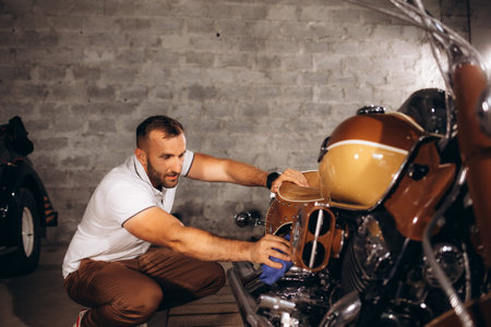 a man wipes his retro motorcycle.の写真素材