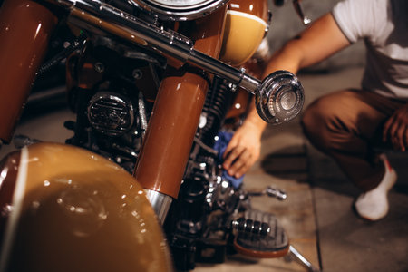 a man wipes his retro motorcycle.の写真素材