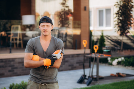 handsome young man gardener trimming hedgerow in a garden park outdoor.の写真素材