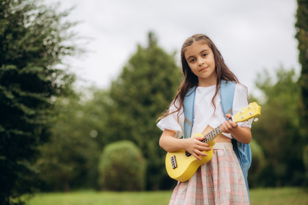 Lovely girl,playing guitar, singing and smiling joyfully , in casual cloth with brown wool hat, music or happiness concept, sunset warm light tone effect. High quality photoの写真素材