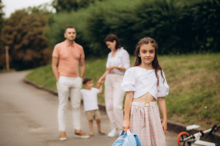 a little girl goes to school, her family in the background.の写真素材