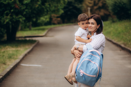 Child going back to school. Mother and kid getting ready for first school day after vacation. Little boy and mom going to kindergarten or preschool. Student packing books, apple and lunch in backpack. High quality photoの写真素材