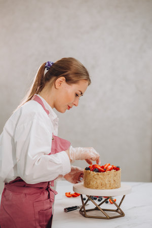 Woman decorating chocolate cake in the kitchen. Female making chef a cake at home. High quality photoの写真素材