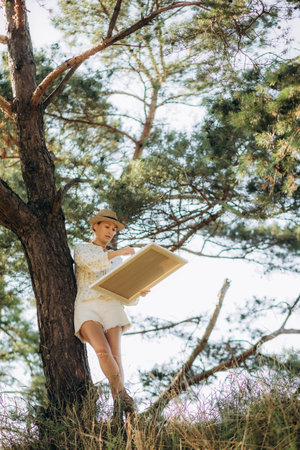 a middle-aged female artist paints a picture in nature. High quality photoの写真素材