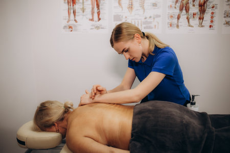 High angle view of a physiotherapist massaging a senior woman's back in the medical office. High quality photoの写真素材