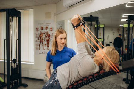 a rehabilitator works out with an older woman in the gymの写真素材