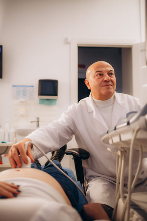 Gynecologist doctor does ultrasound, sonogram procedure to a pregnant woman. Doctor makes the...