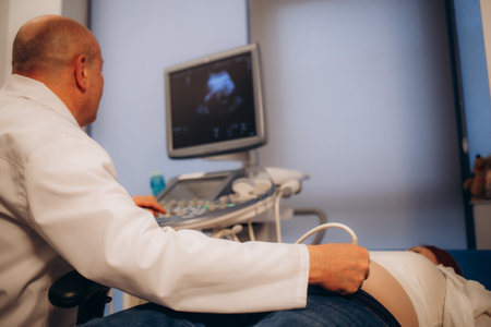 close up of asian pregnant woman lying in hospital ward has uterus utltrasonographic diagnosis - female doctor scans her uterus and shows on screen. High quality photoの写真素材
