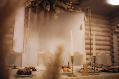 The groom's and bride's table is decorated with candles, flowers, brilliant cloth in a classic luxury style. Wedding decorations in the great white hall of the restaurant. front View.の写真素材