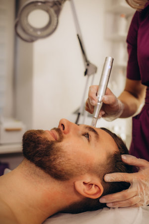 Dermastamp fractional mesotherapy treatment for man in cosmetology clinic. High quality photo