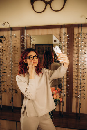 A Young female customer trying on glasses and taking a selfie in optical center, Eyecare concept....