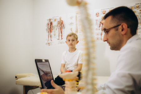 Chiropractor or osteopath does acupressure on back of child with back pain. High quality photo