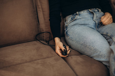 the woman uses the remote control to open the footrest in the sofa