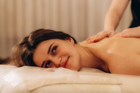Beautiful young woman relaxing with hand massage at beauty spaの写真素材