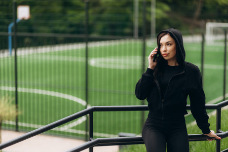 Sportswoman looking at her mobile phone in a beautiful parkの写真素材