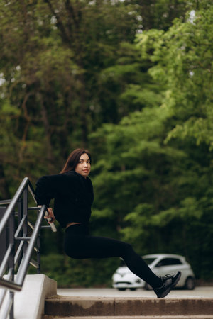 Young woman warming up at the stairway. Fit runner stretching her muscle before workout at stadium...