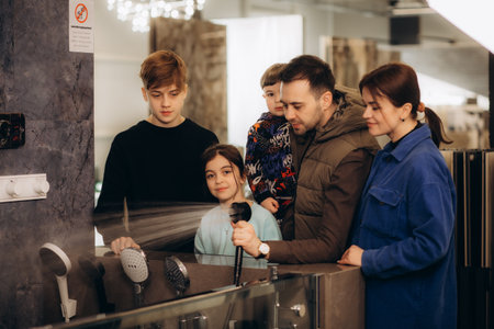 A young large family chooses a shower system in a storeの写真素材
