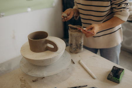 Female master paints a pot, pottery workshopの写真素材