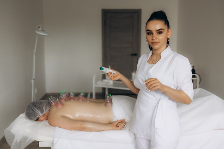 A woman undergoing a massage using vacuum plastic jars.の写真素材