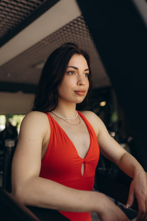 Shot of young woman in sportswear bending with her hands on knees at the gym. Fitness woman looking tired after intense crossfit workout.の写真素材