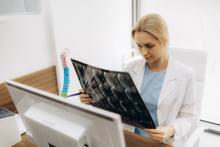 Female doctor sitting at desk explaining medical scan, looking away