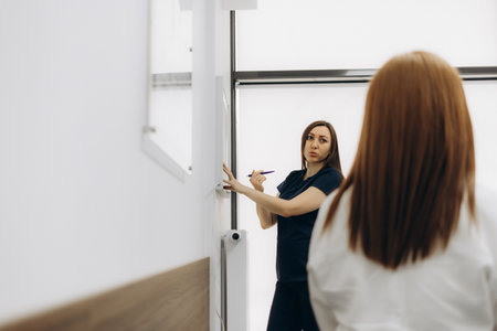 Female doctor in clinic show x-rays to male patient.の写真素材