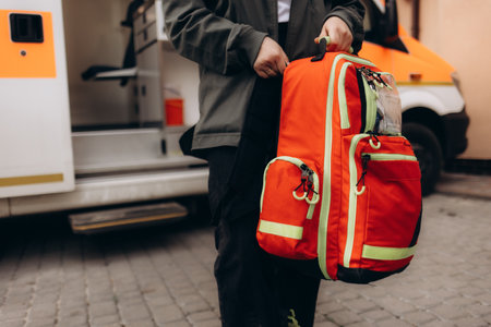 A backpack in orange and grey color with a red first aid kit is ideal for outdoor activities like hiking and camping, offering necessary supplies for safety during wilderness adventuresの写真素材