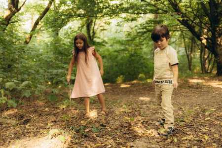 A little girl in the forest walking with a boyの写真素材